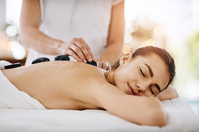 Buy stock photo Relax, hot stone and woman getting a back massage at a spa for luxury, calm and natural self care. Beauty, body care and tranquil female person sleeping while doing a rock body treatment at a salon.