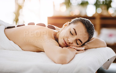 Buy stock photo Hot stone massage, relax and woman in spa for massage, peace or stress relief. Beauty, rocks on back of person in salon for body therapy and wellness treatment or healthy detox with eyes closed