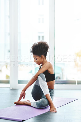 Buy stock photo Shot of a beautiful young woman practising yoga in a studio