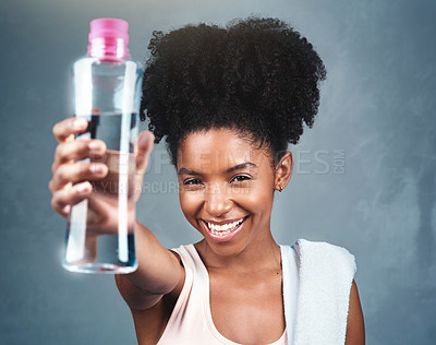 Buy stock photo Shot of a sporty young woman holding up a bottle of water