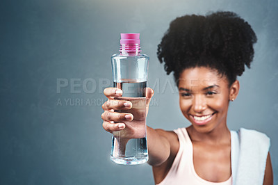 Buy stock photo Fitness, bottle and happy woman with water offer in studio for training, workout or hydration satisfaction on grey background. Sports, liquid or athlete smile for hydrogen, drink or exercise recovery