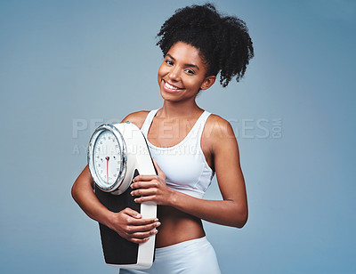 Buy stock photo Black girl, portrait and scale in studio for weight loss, confident measure and blue background. Female person, fitness and diet for balance, mockup space and proud of weightloss success and health