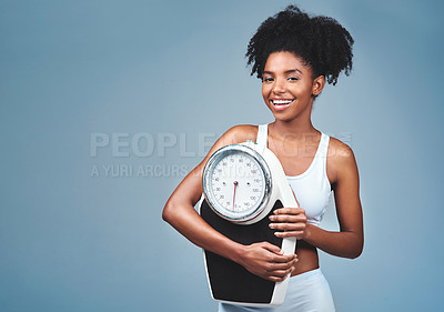 Buy stock photo Black girl, portrait and scale in studio to measure weight loss, confident and blue background. Female person, fitness and diet for balance, mockup space and proud of weightloss success and health
