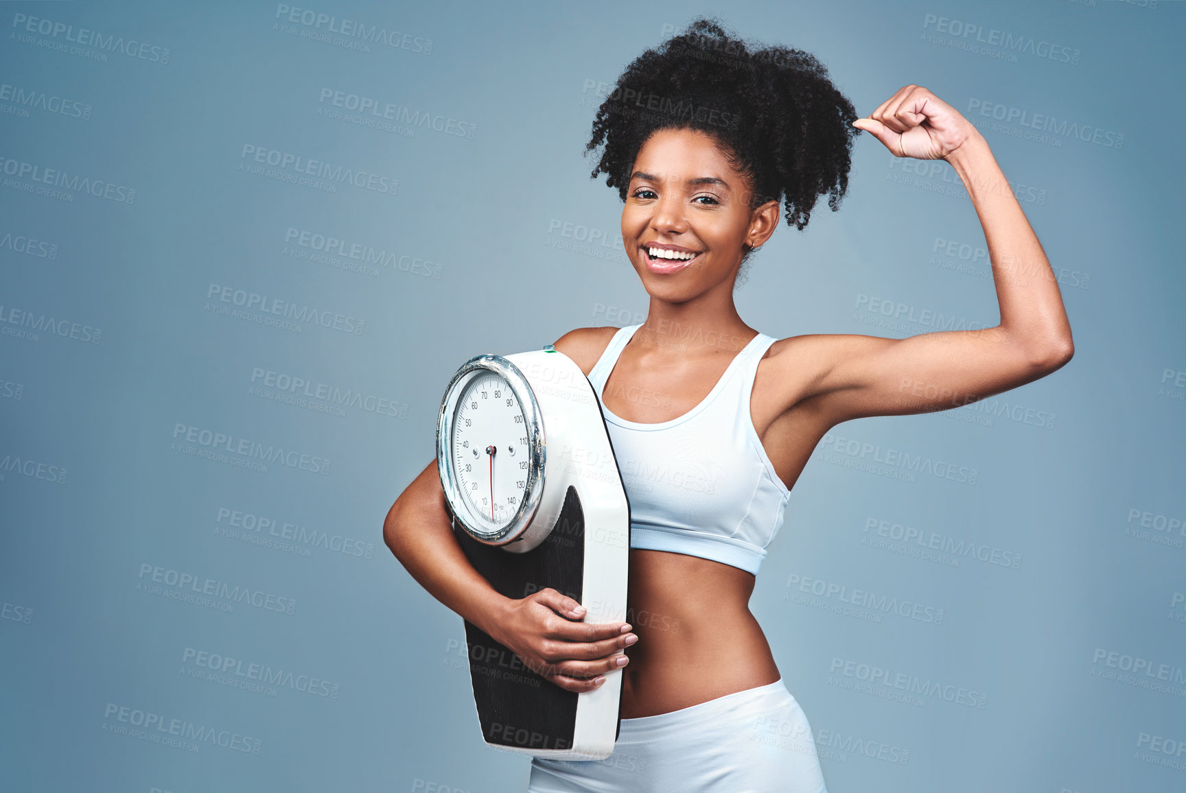 Buy stock photo Black girl, portrait and bicep for scale in studio, weight loss and confident measure on blue background. Female person, fitness and diet for balance, mockup space and strong proud for empowerment