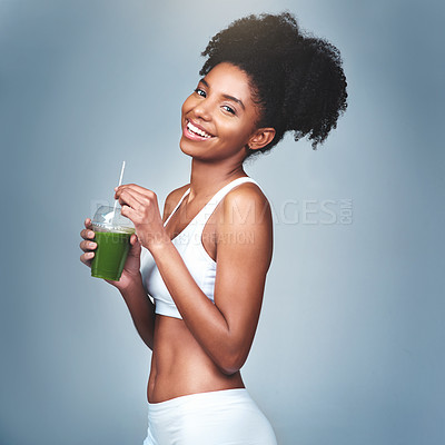 Buy stock photo Studio shot of an attractive young woman drinking green juice against a grey background