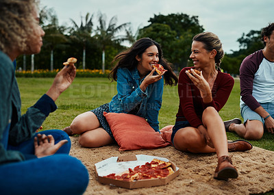 Buy stock photo Cropped shot of a group of young friends having pizza together during a picnic in a park