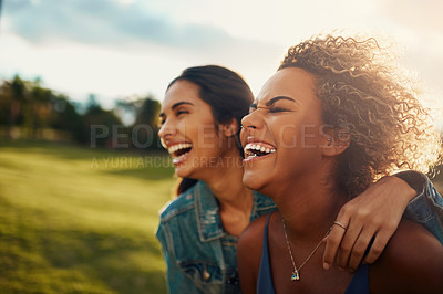 Buy stock photo Cropped shot of two attractive young girlfriends having a laugh together at a park