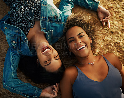 Buy stock photo High angle shot of two attractive young girlfriends lying down together outdoors