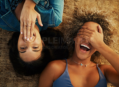 Buy stock photo High angle shot of two attractive young girlfriends lying down together outdoors