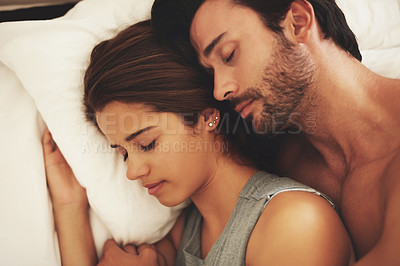Buy stock photo Shot of a young couple sleeping peacefully together at home