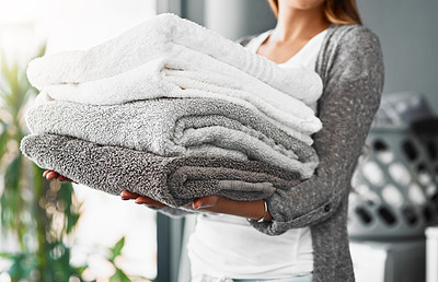 Buy stock photo Cropped shot of an unrecognizable young woman doing her laundry at home