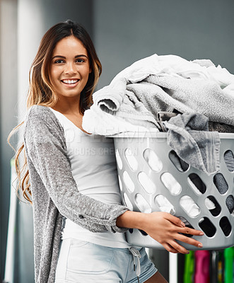 Buy stock photo Cropped portrait of an attractive young woman doing her laundry at home