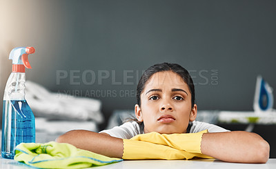 Buy stock photo Cropped portrait of a young woman looking bored while cleaning a table at home
