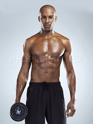 Buy stock photo Studio shot of an unrecognizable young athletic man holding a dumbbell while standing against a grey background