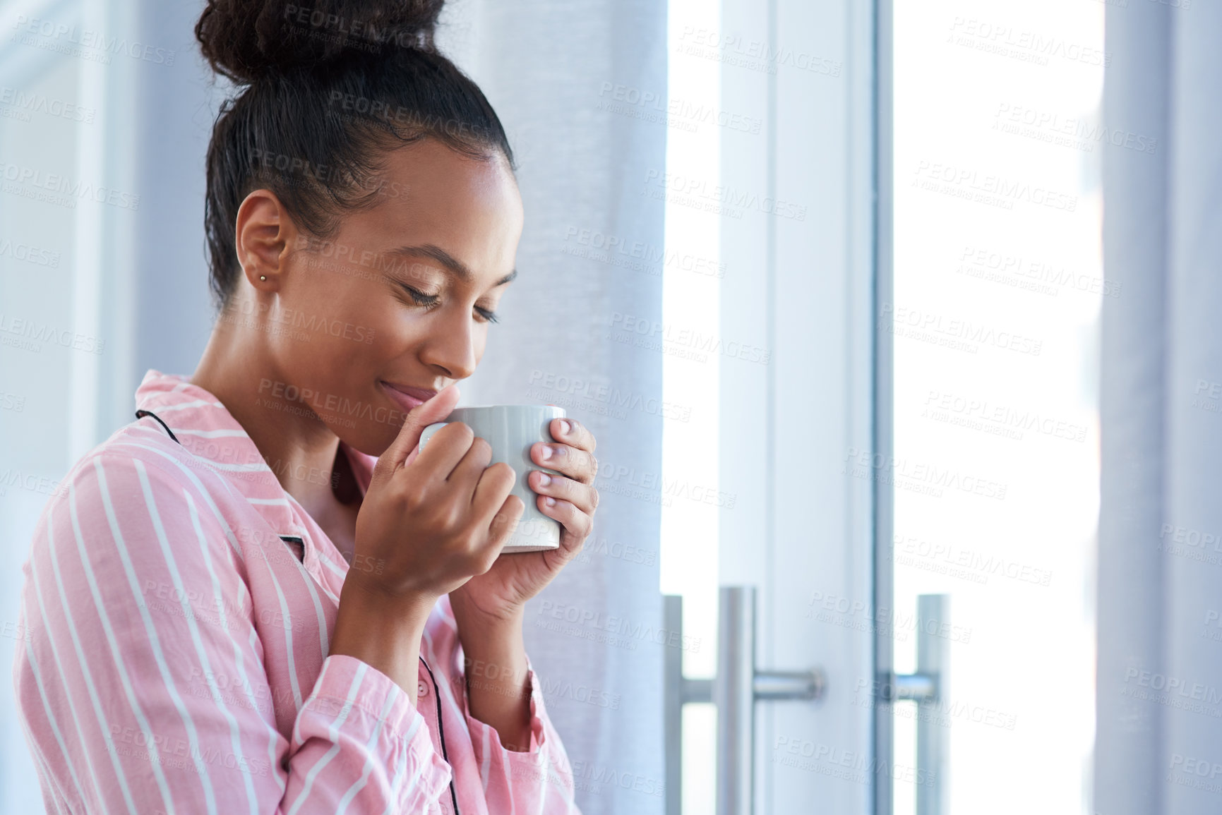 Buy stock photo Shot of an attractive young woman enjoying her morning coffee at home