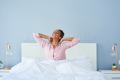 Buy stock photo Shot of a happy young woman waking up in bed in the morning
