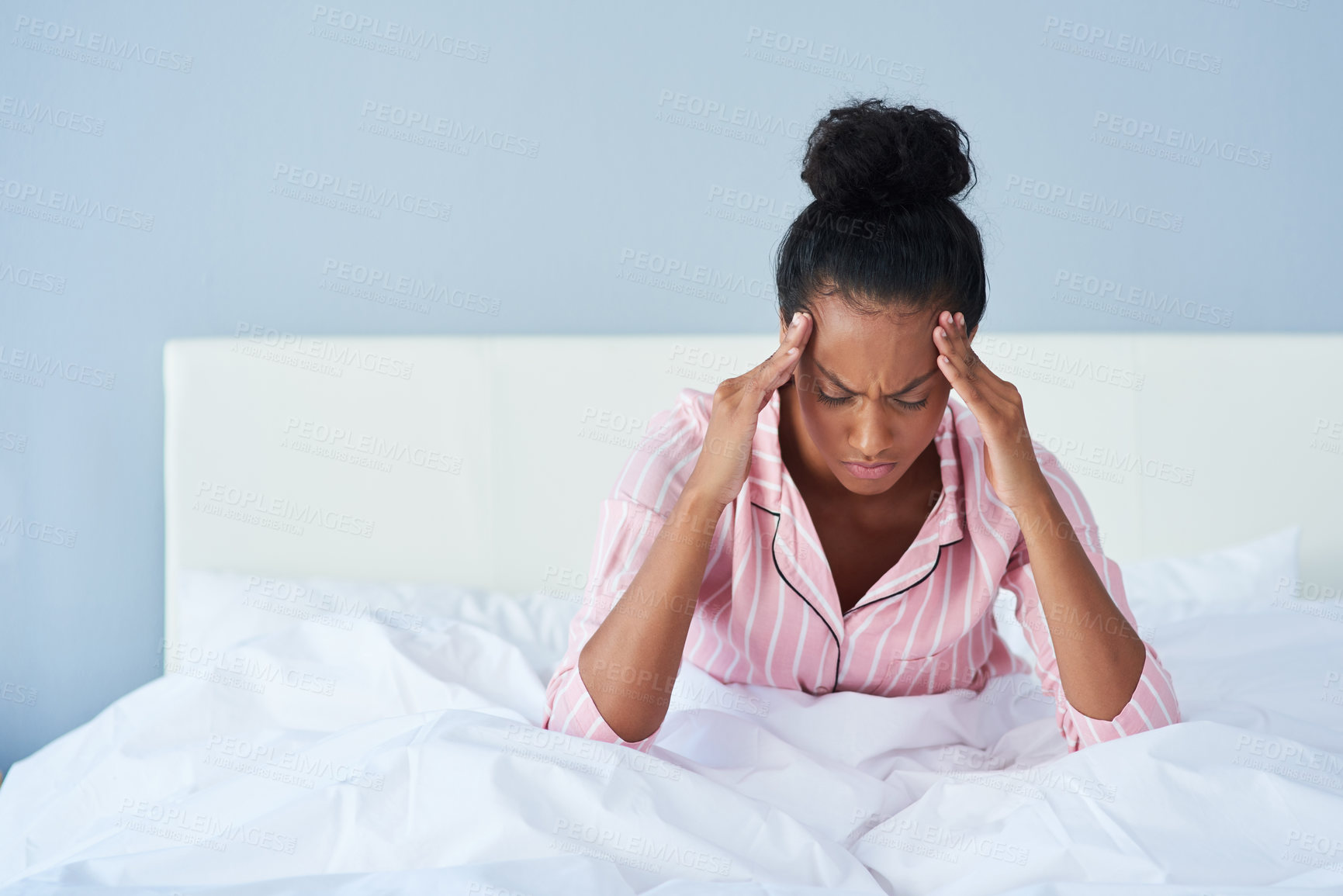 Buy stock photo Shot of a young woman suffering from a headache in bed at home