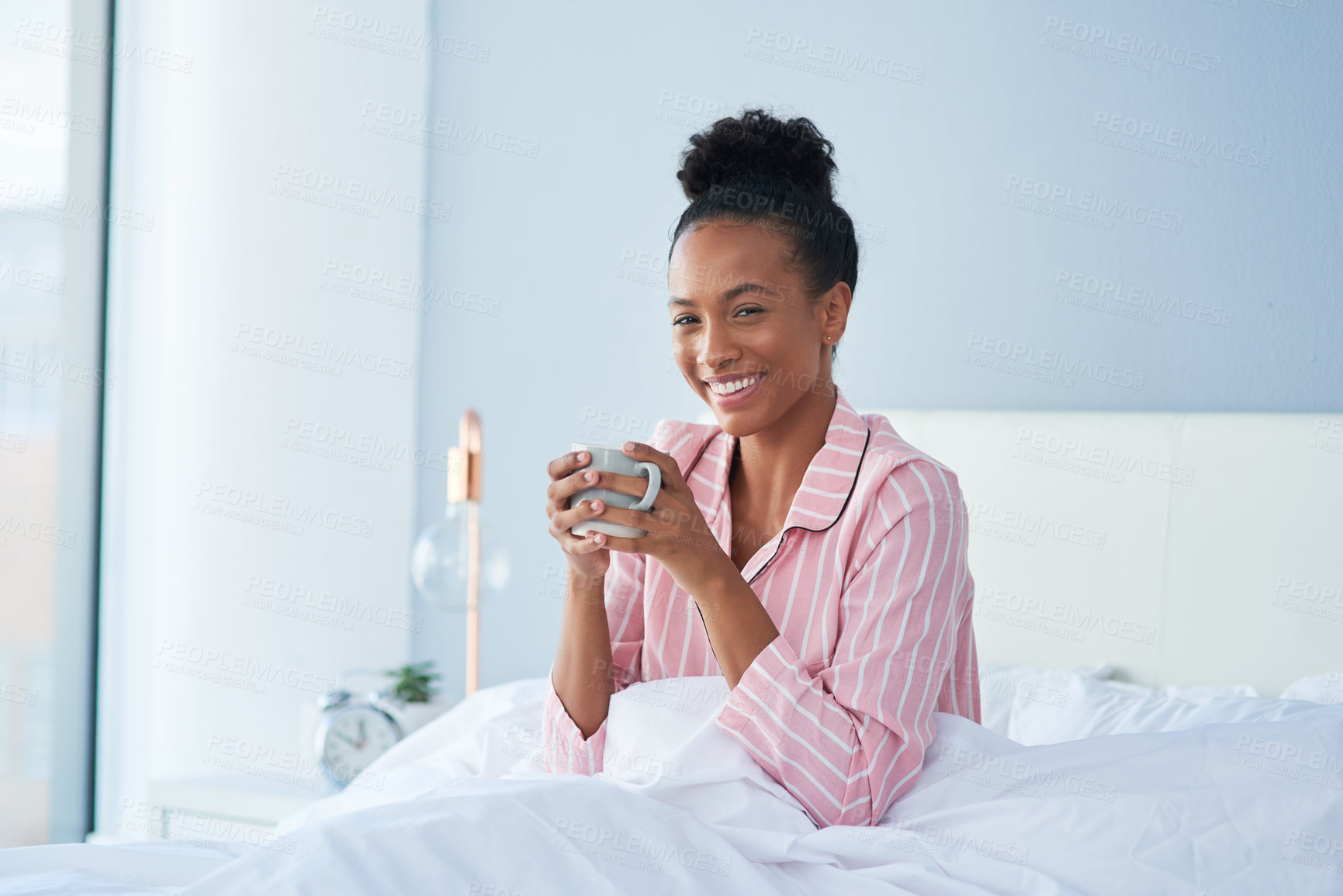 Buy stock photo Shot of an attractive young woman enjoying her morning coffee in bed at home