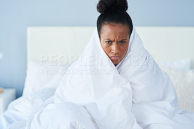 Buy stock photo Shot of an attractive young woman wrapped around in a blanket and sulking in bed at home