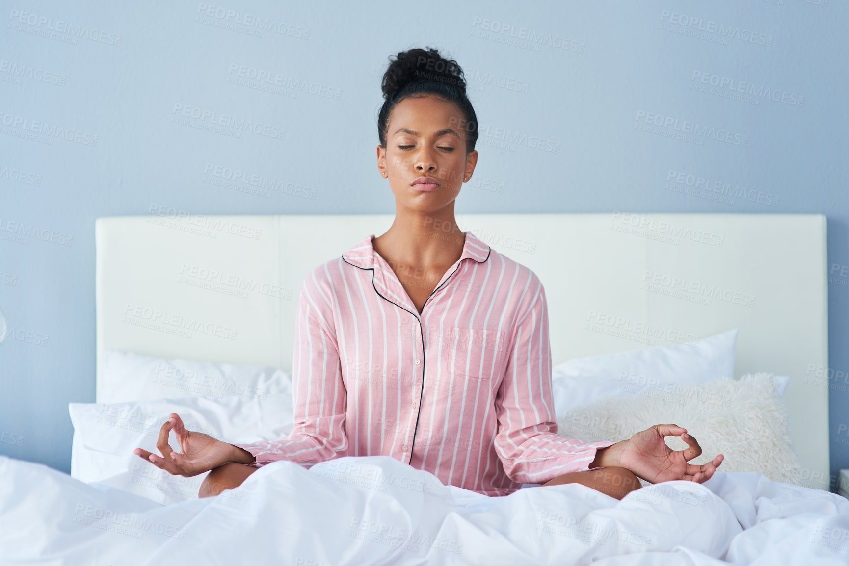 Buy stock photo Shot of an attractive young woman meditating in bed at home