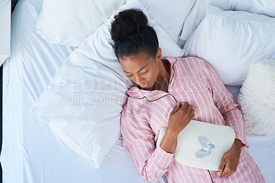 Buy stock photo High angle shot of an attractive young woman peacefully sleeping in bed at home