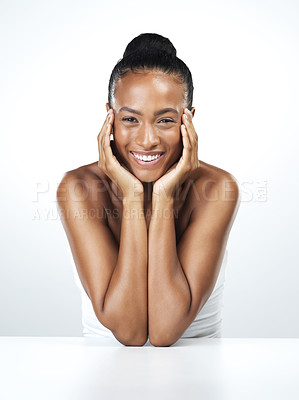 Buy stock photo Studio portrait of an attractive young woman resting her face in the palm of her hands while standing against a white background