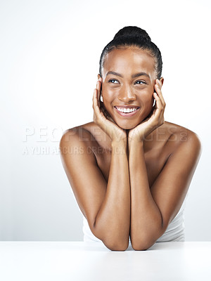 Buy stock photo Studio shot of an attractive young woman resting her face in the palm of her hands while standing against a white background