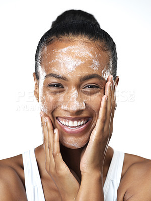 Buy stock photo Studio portrait of an beautiful young woman applying skin moisturizer to her face while standing next to a white background