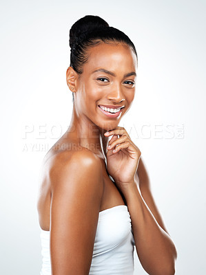 Buy stock photo Studio portrait of an attractive young woman posing and gently touching her neck while standing against a white background