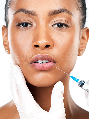 Buy stock photo Studio portrait of an attractive young woman receiving a botox injection in her face while standing against a white background
