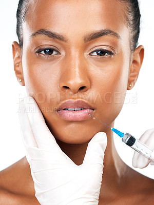 Buy stock photo Studio portrait of an attractive young woman receiving a botox injection in her face while standing against a white background