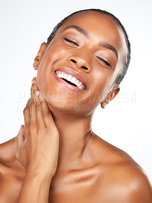 Buy stock photo Studio shot of an attractive young woman posing and gently touching her neck while standing against a white background