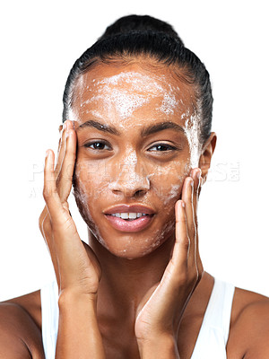 Buy stock photo Studio portrait of an beautiful young woman applying skin moisturizer to her face while standing next to a white background