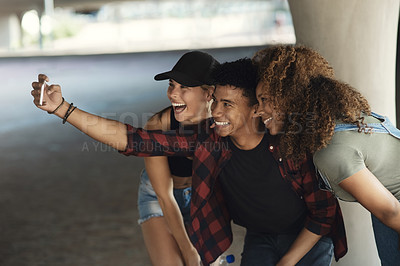 Buy stock photo Shot of a group of cheerful young friends posing for a self portrait together while outside in a parking lot