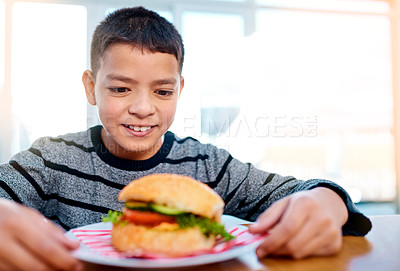 Buy stock photo Boy, hamburger and eating in home for dinner meal with smile, tasty fast food and nutrition. Hungry kid, tomato and weekend lunch for beef burger at restaurant with buns, cucumber and green color