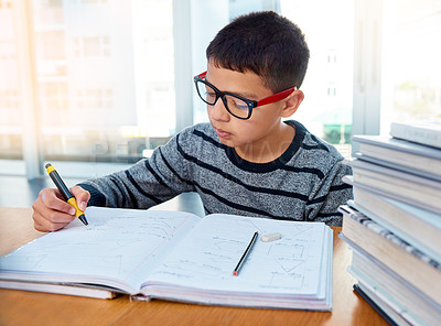 Buy stock photo Boy child, student and writing for studying, homework or learning in education with book on table at home. Smart little kid busy on mathematics, textbooks or problem solving for study in living room