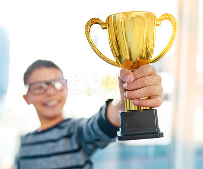 Buy stock photo Trophy, winner and kid in home with home prize for school work, growth and child development with success. Education, achievement and champion boy with students award for learning, exam or creativity