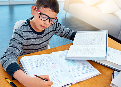 Buy stock photo Child boy, student and writing on math book in studying, learning or education on table at home. Smart little kid busy with mathematics homework, textbook or problem solving on living room study desk