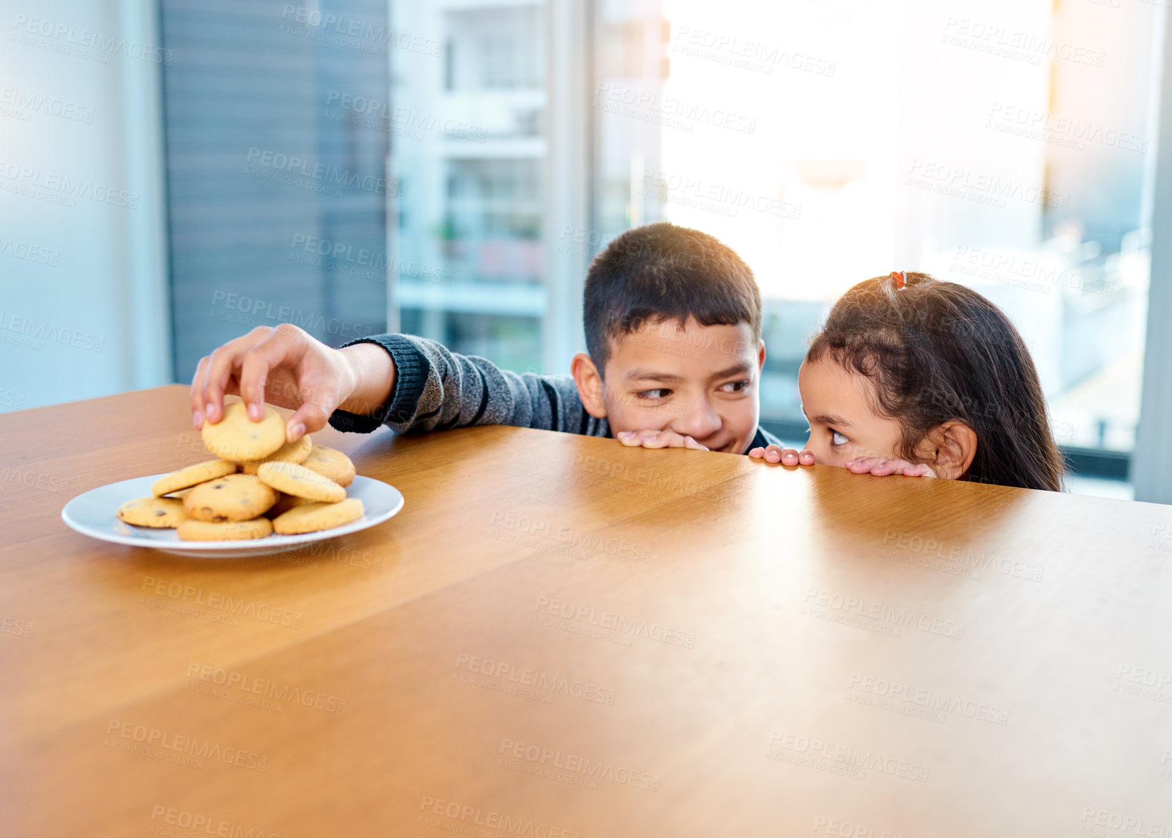 Buy stock photo Home, brother and sister in kitchen, biscuits and siblings together, boy and girl in morning or hungry. House, kid and cute child for food or cookies on table, plate and bonding or dessert in weekend