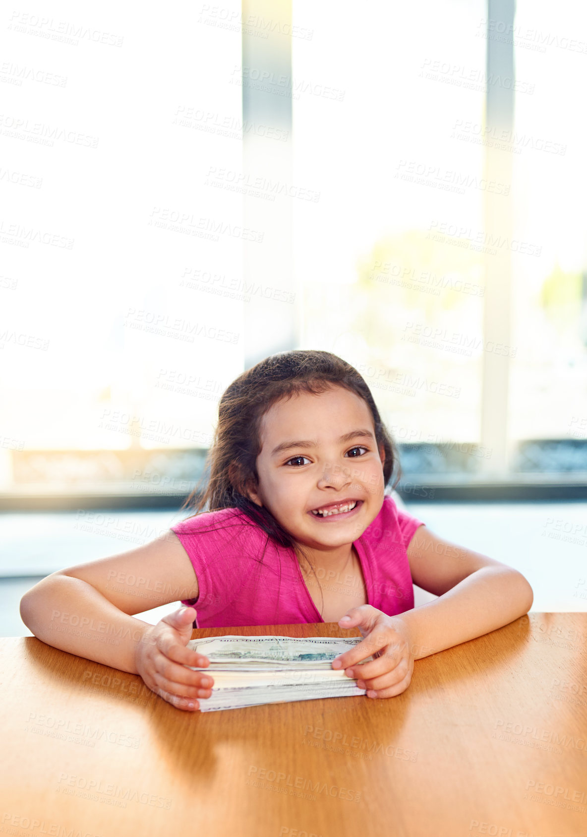 Buy stock photo Shot of an adorable little girl holding a stack of money while sitting at the dinner table at home