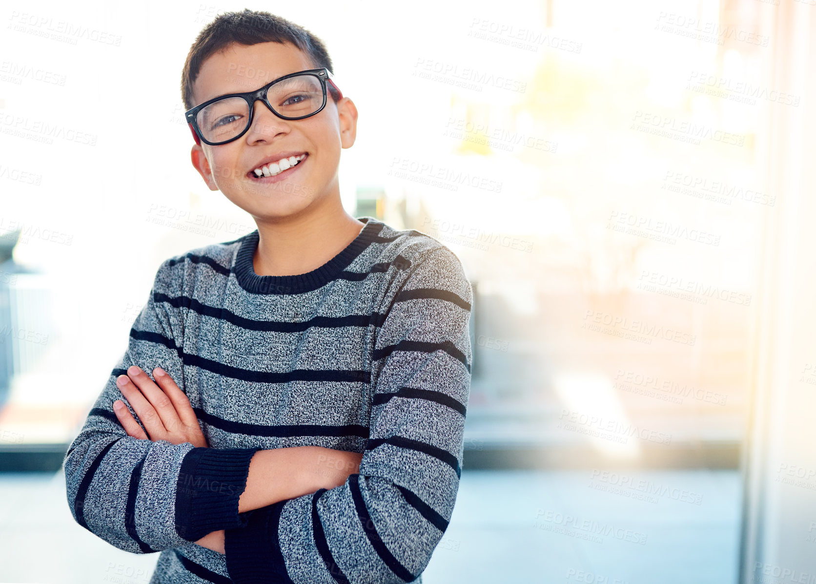 Buy stock photo Happy, young boy and arms crossed with glasses for eye care and optometry indoor at home with lens flare. Smile, male child and spectacles for vision and sight for learning, development and growth