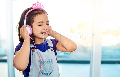 Buy stock photo Shot of an adorable little girl listening to some music on her headphones at home