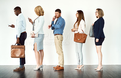 Buy stock photo Studio shot of a group o focused people standing in a row behind each other against a white background