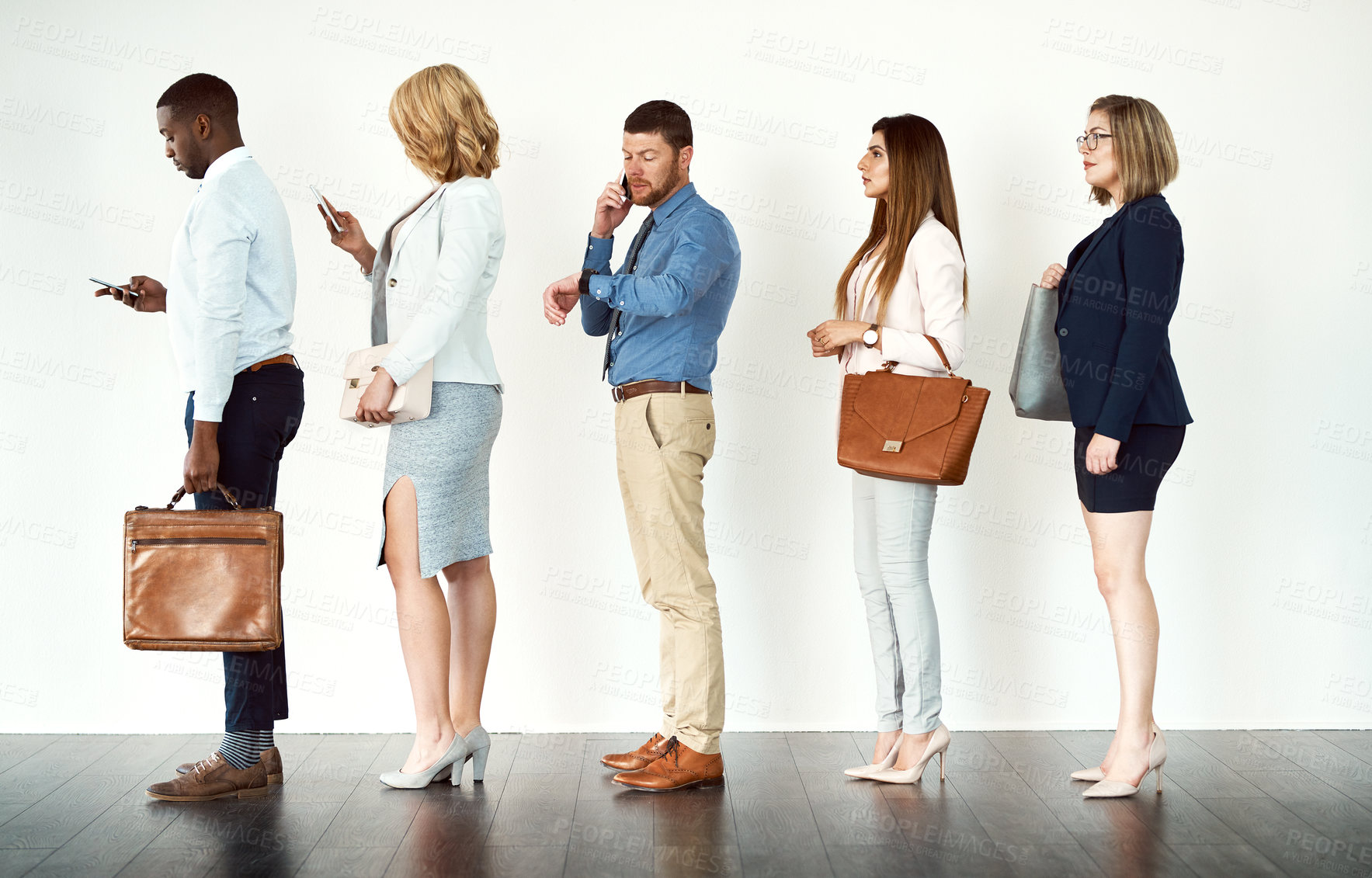 Buy stock photo Studio shot of a group o focused people standing in a row behind each other against a white background