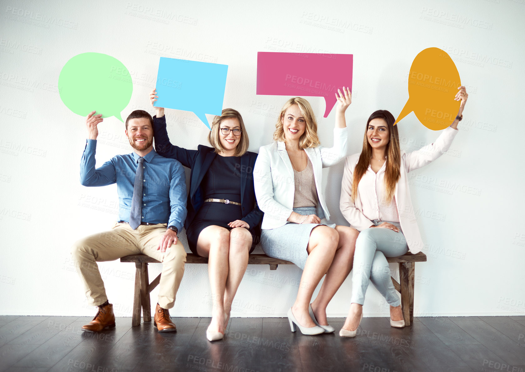 Buy stock photo Shot of a group of work colleagues seated next to each other while holding speech bubbles against a white background