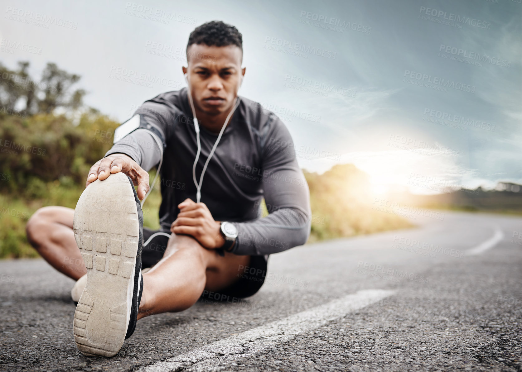 Buy stock photo Black man, portrait and stretching legs on road for fitness or muscle preparation with serious for workout. Wellness, running and motivation for mindset with training, music and health or cardio