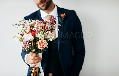 Buy stock photo Studio shot of a unrecognizable young groom holding a bunch of flowers a gray background