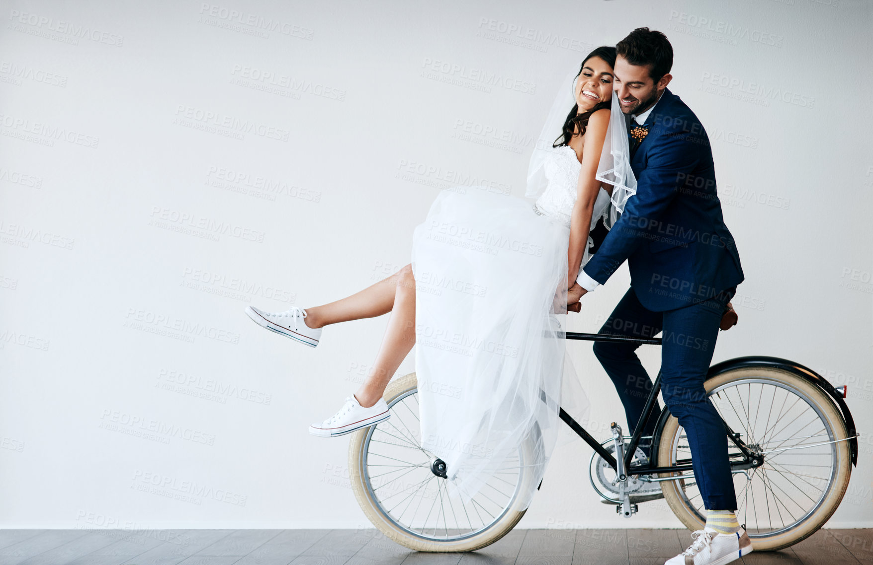 Buy stock photo Happy couple, wedding bride and groom on bicycle for travel, love and mockup space. Newlyweds, man and woman on bike for marriage, cycling and celebrate romantic honeymoon on white wall background