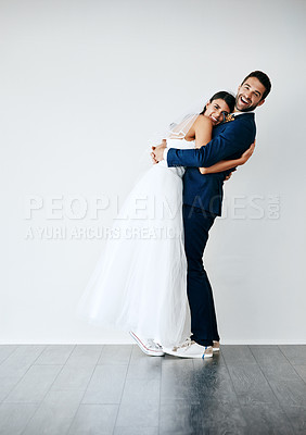Buy stock photo Studio shot of a newlywed couple standing against a gray background