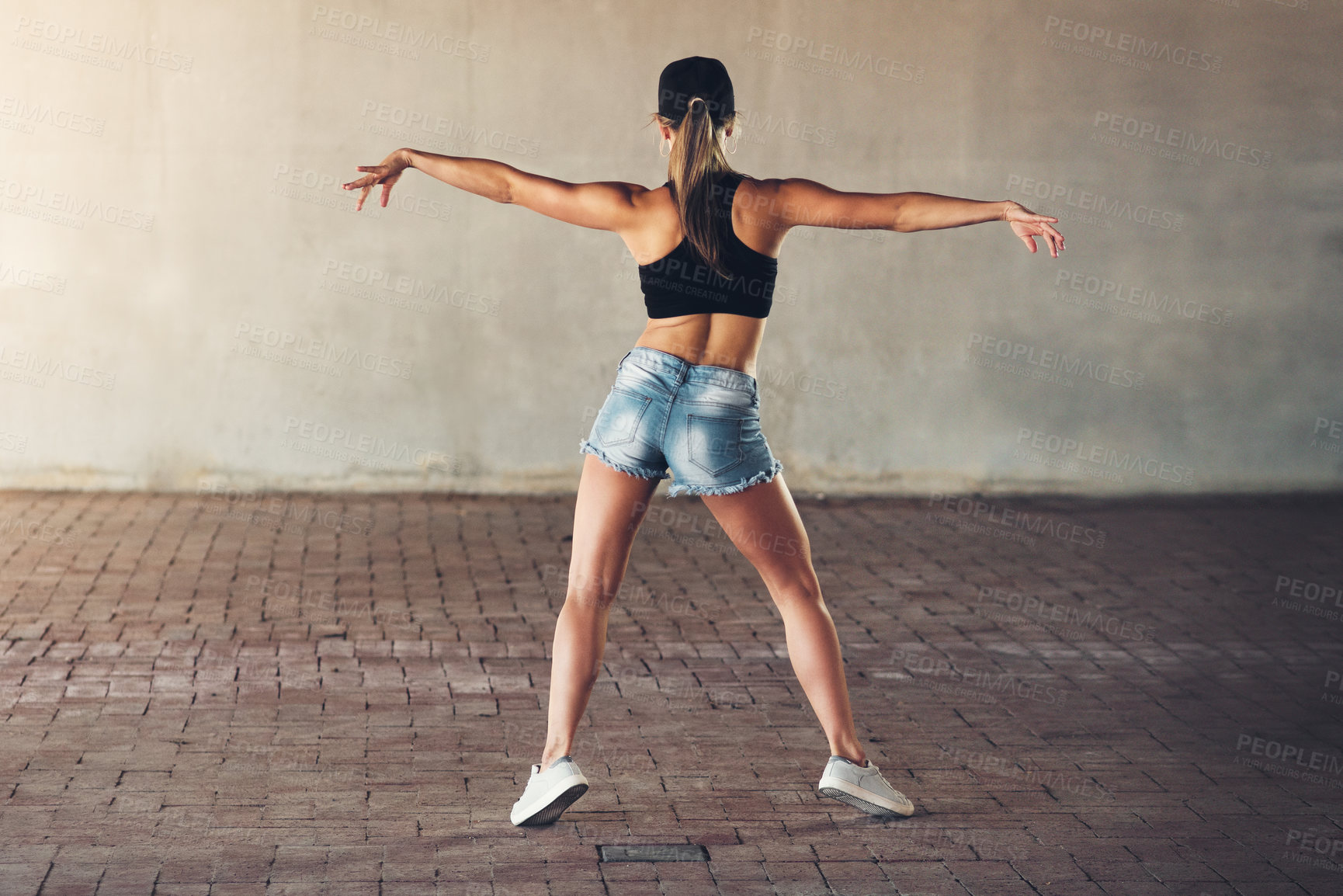 Buy stock photo Rearview shot of a female street dancer practising out in the city